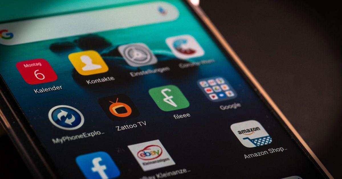 贝贝bilibili App 主界面在手机屏幕上呈现的深色视频社区首页，推荐流卡片整齐排列，暖色灯光映衬着浏览中的用户侧脸